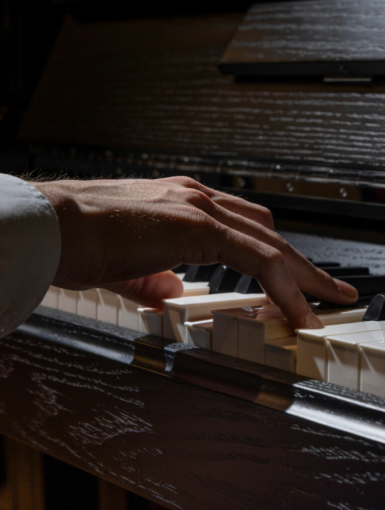 Main jouant du piano en clair-obscur